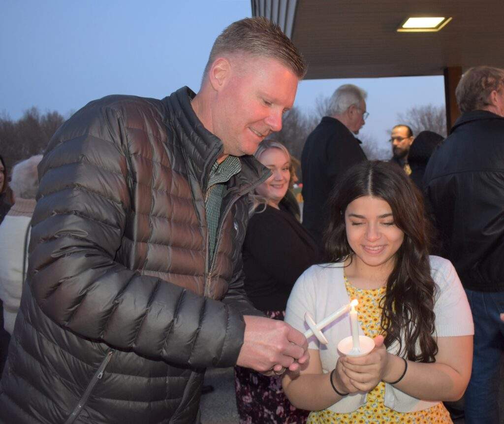 Father and daughter light their candles at the Easter Vigil