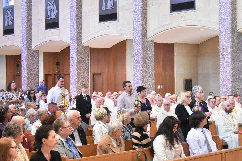 Lay people from various parishes present the oil and chrism for blessing.