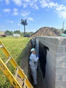 A volunteer scrubs the exterior of the foundation