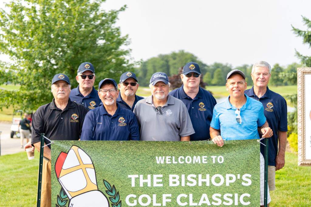 group shot in front of bishop golf classic banner