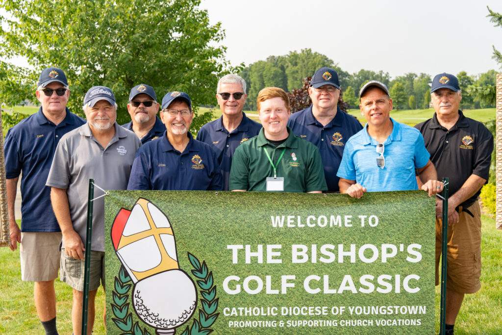 group shot in front of bishop golf classic banner