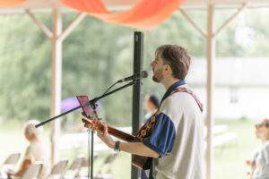 Man plays guitar and sings during Mass