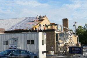 Men work on a tall roof.