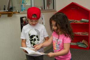 Kids read a book together.