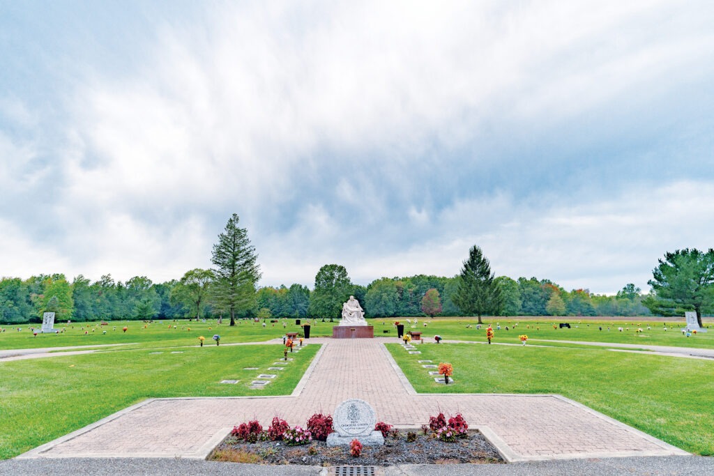 Landscape including a statue at All Souls Cemetery in Warren.