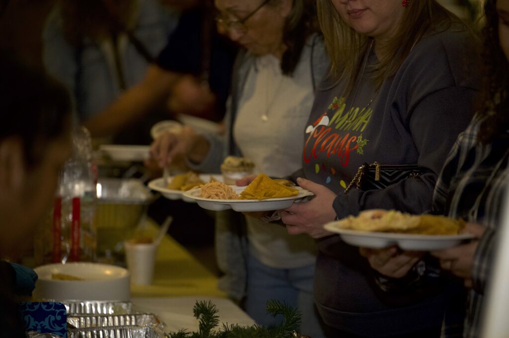 People go through the buffet at the Las Posadas celebration