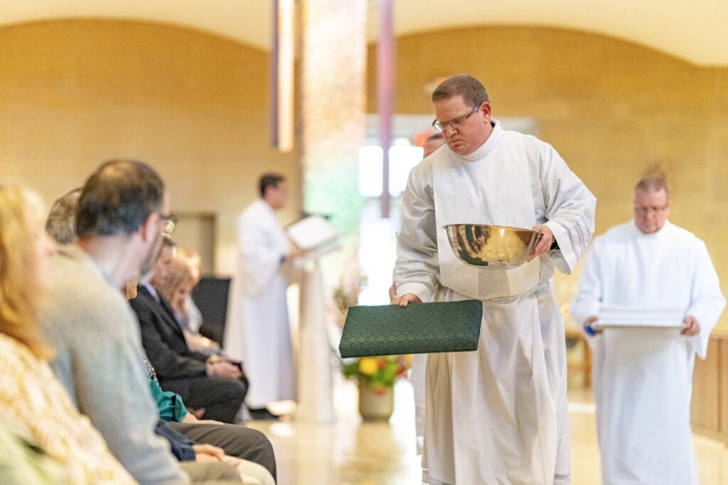 Deacon Kevin Bertleff assists the bishop in washing feet on Holy Thursday 2024. Photo by Brian Keith.