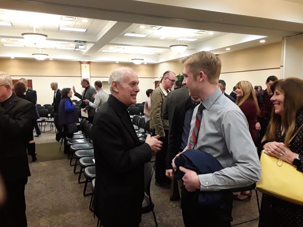 The archbishop greets guests after the program.