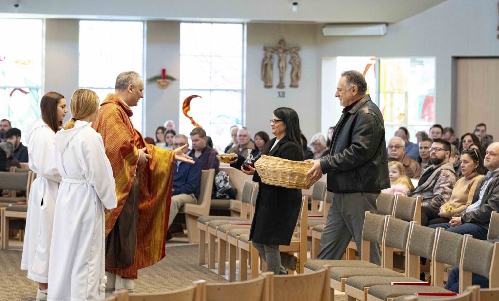 A man and woman bring up the gifts. Photo by Brian keith