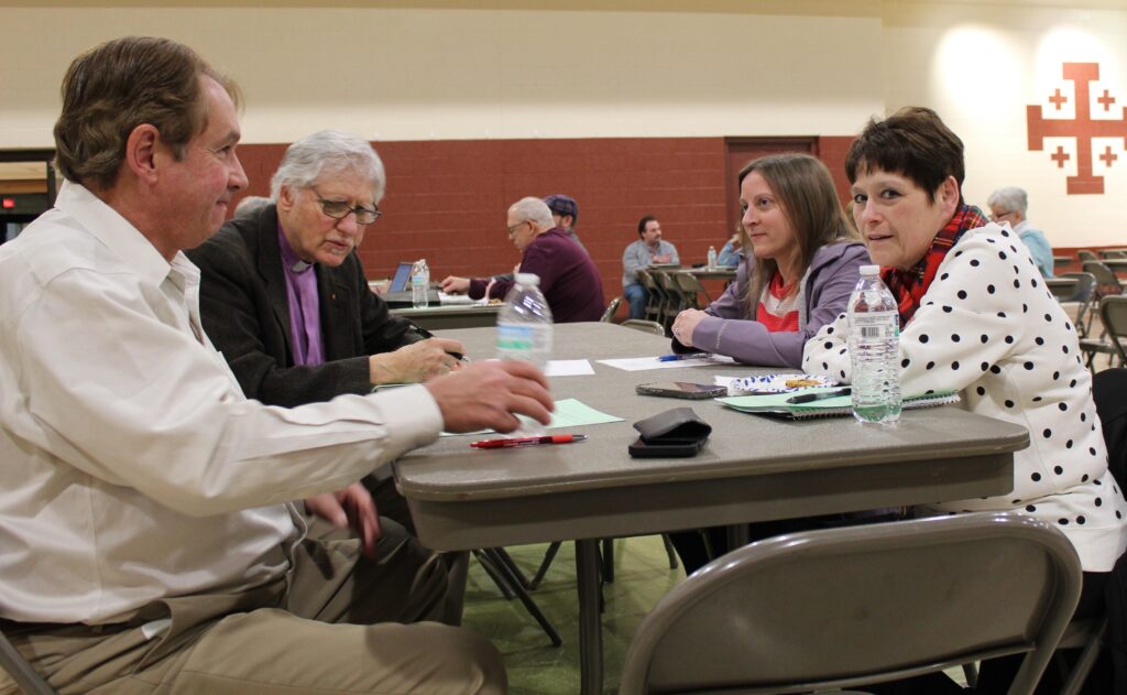 Attendees sitting around a table debate questions