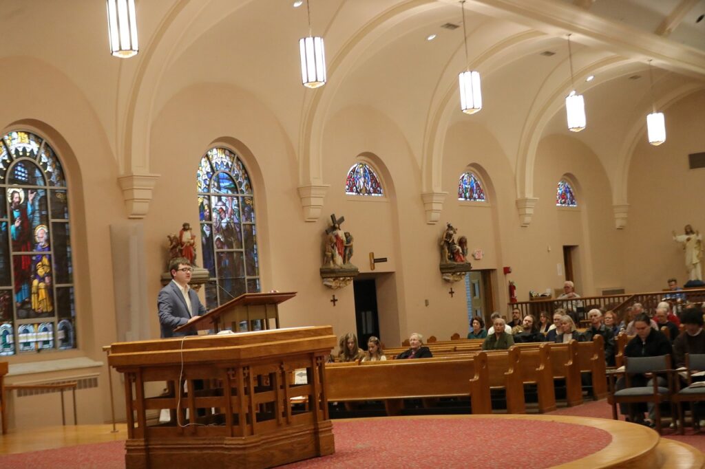 Male lector speaks from the ambo at St. Paul Parish in North Canton on Good Friday 2024. Photo by Ed Hall, Jr.