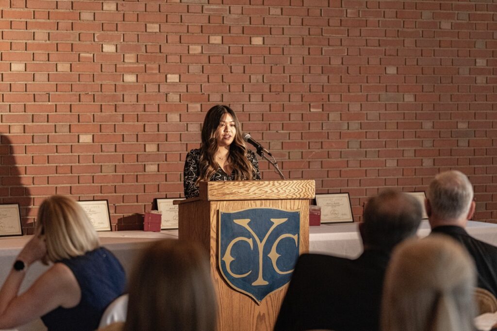 Woman with dark hair speaks at the podium at at the Golden Apple Awards 2024.
