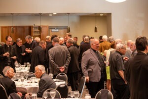 Priests greet each other after Mass on May 8. Photo by Courtney Poullas