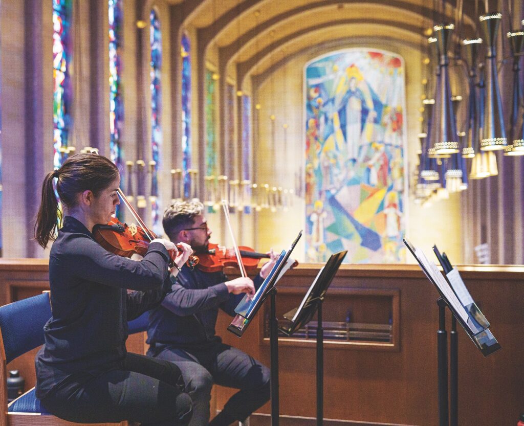 Two string players look at their music intently
