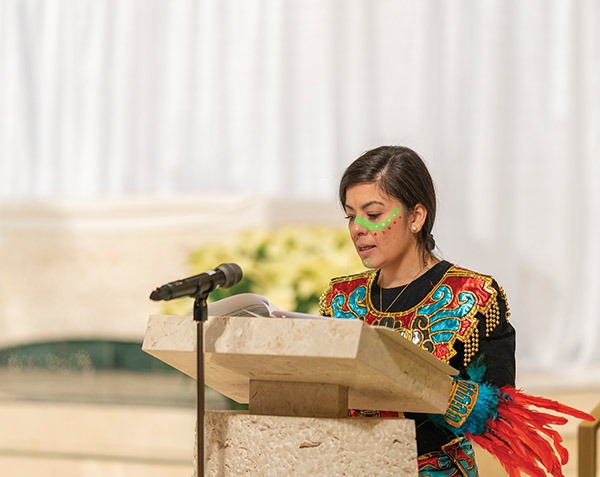 A woman in costume does the reading at the Our Lady of Guadalupe Mass in 2023