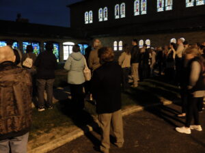 Parishioners stand outside the Saint Joseph the Provider Gallery during its dedication at night