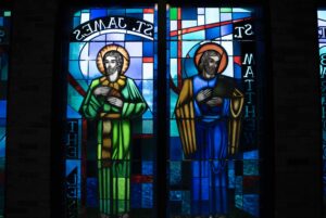 Closeup of two stained glass windows depicting saints