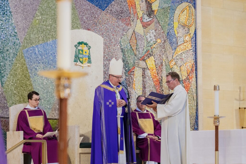 Bishop Bonnar reads from a book during the Rite of Election. Photo by Brian Keith.