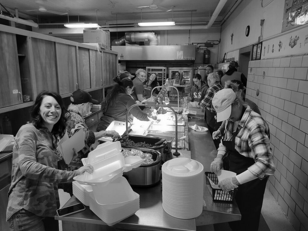 women wash dishes in a kitchen