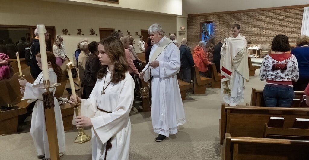 servers walk in procession at Holy Thursday mass