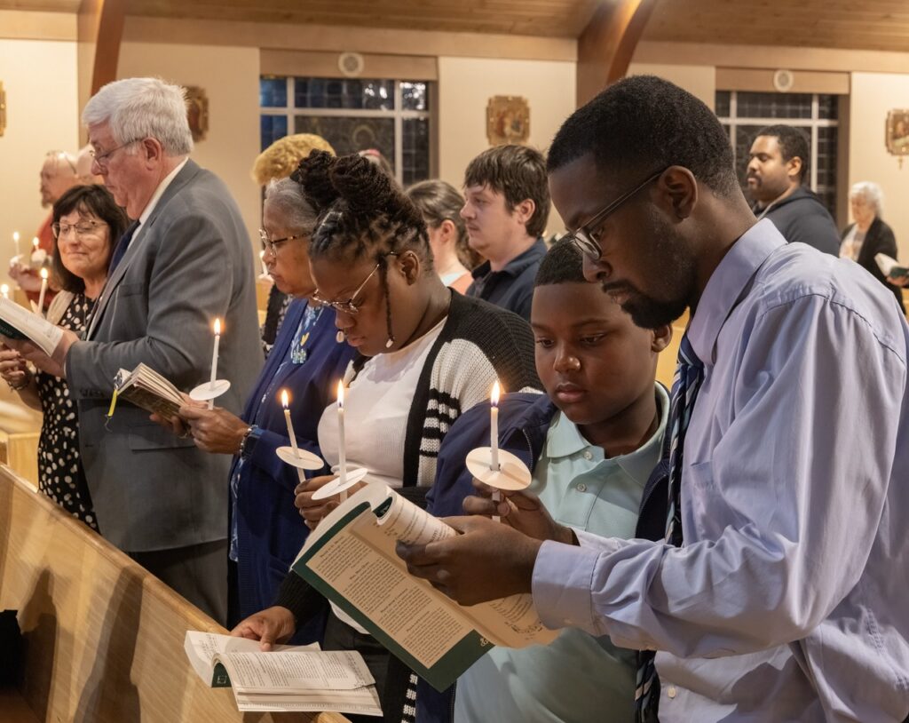 Family sings from a hymnal at St. Ann