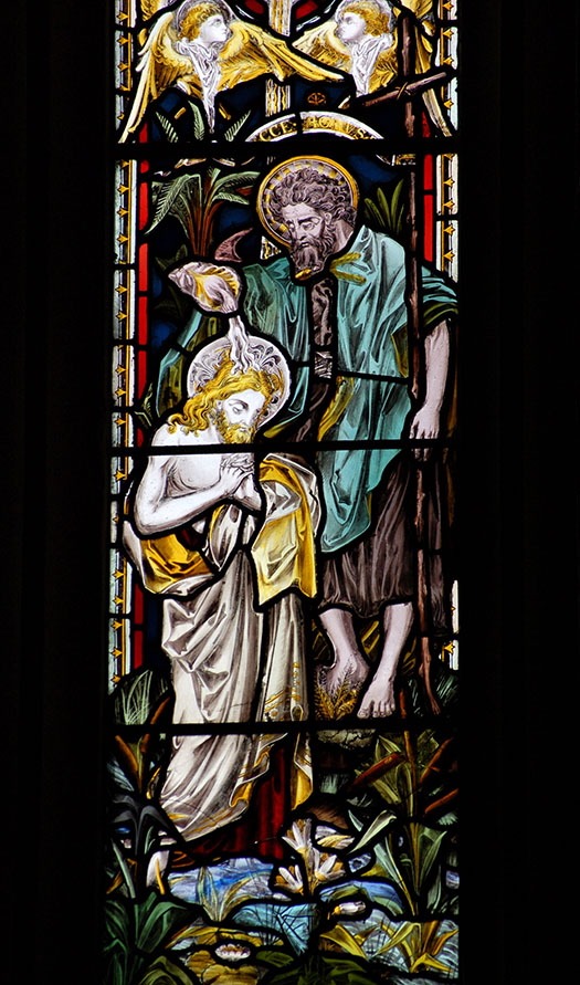 Stained glass window of st john the baptist, pouring water over Jesus' head.
