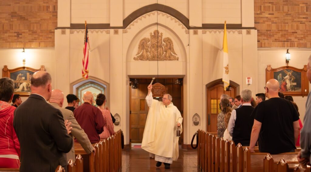 Father performs the sprinking rite at St. Patrick's in Youngstown. Photo by Courtney Poullas.