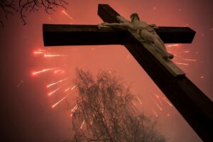 Cross standing in front of July 4 fireworks display.