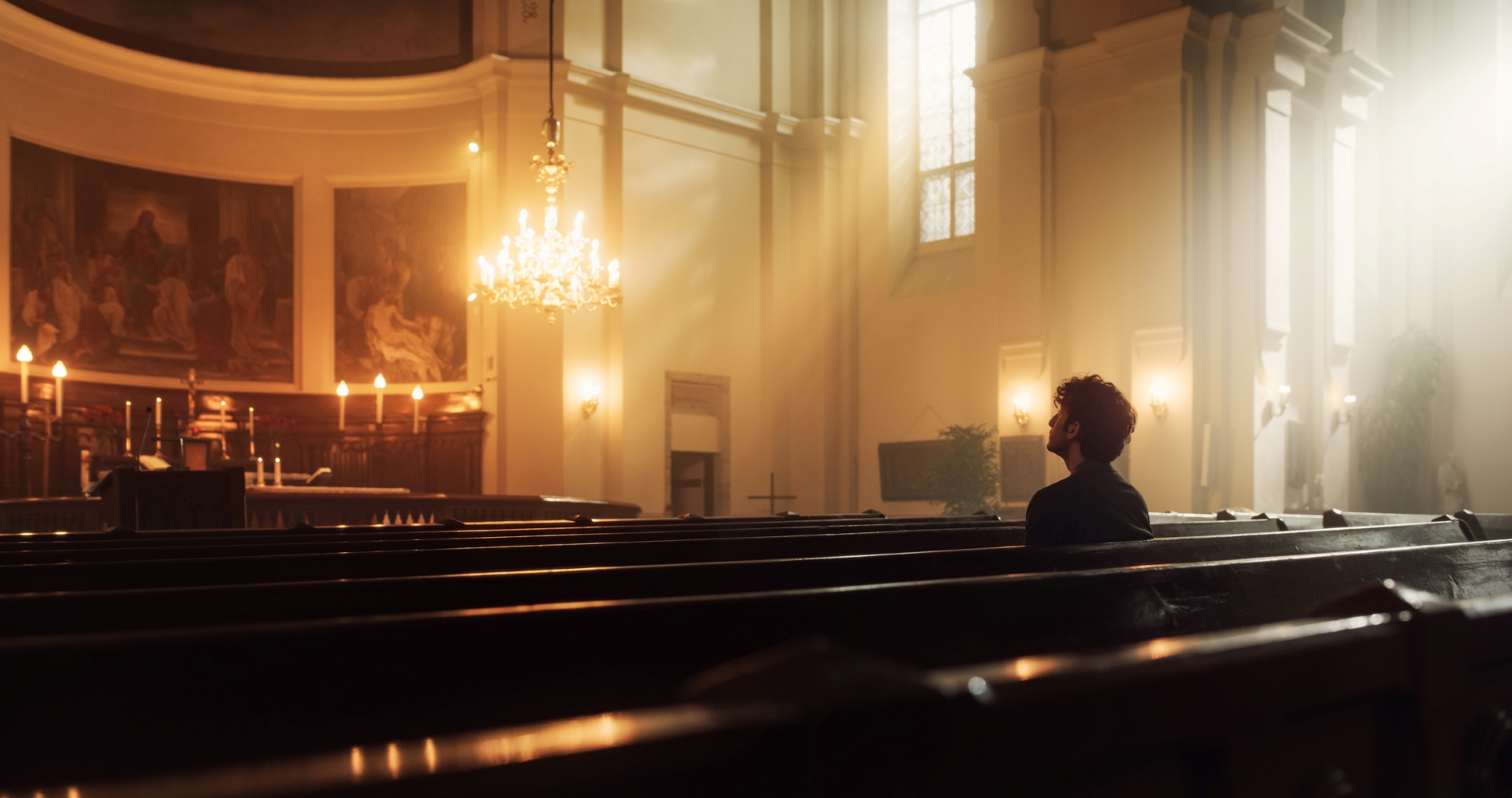 Image shows a man in the pew of a church, seeking God's guidance.