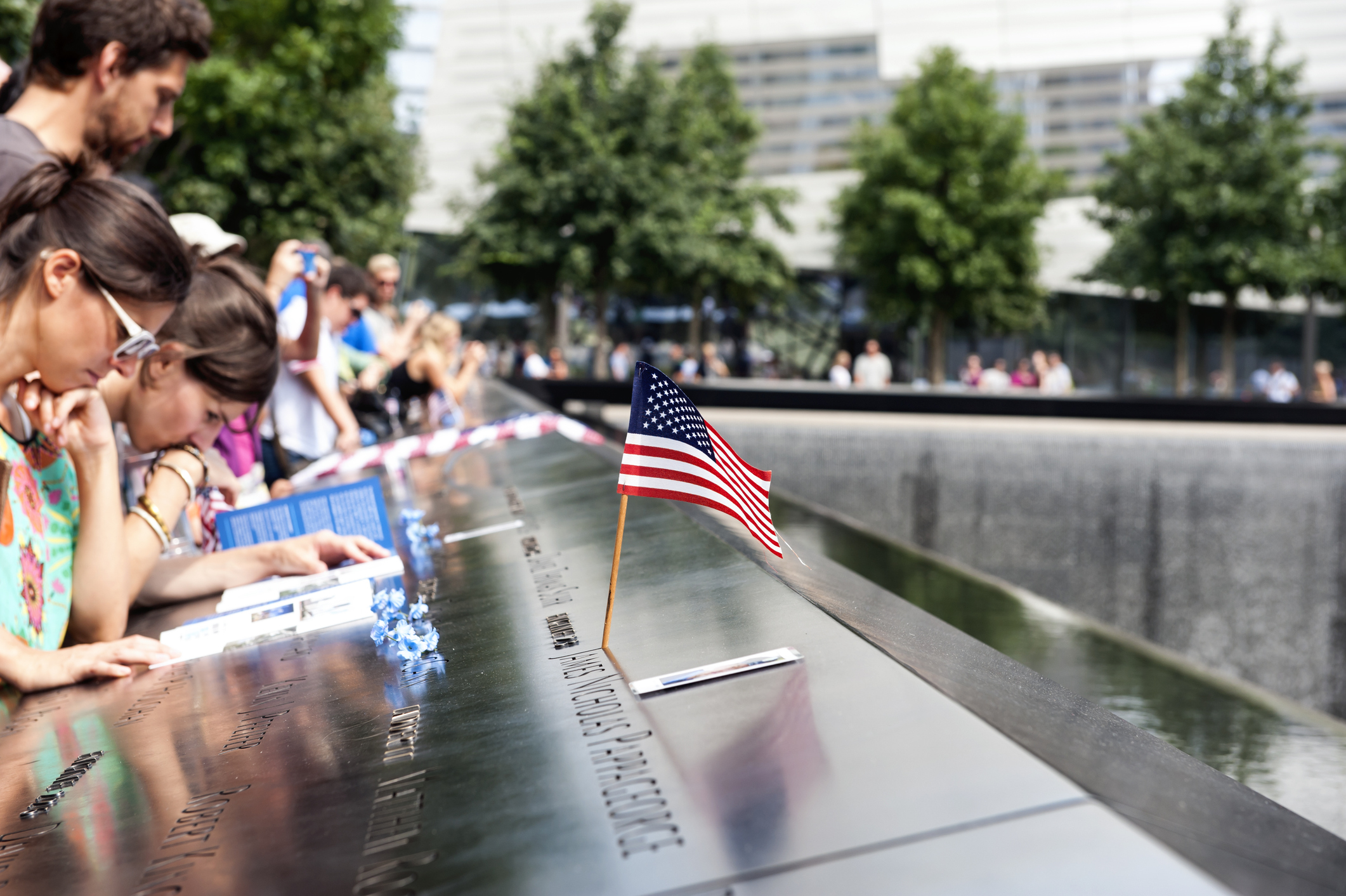 A group of people gather at the memorial of the 9/11 terror attacks.