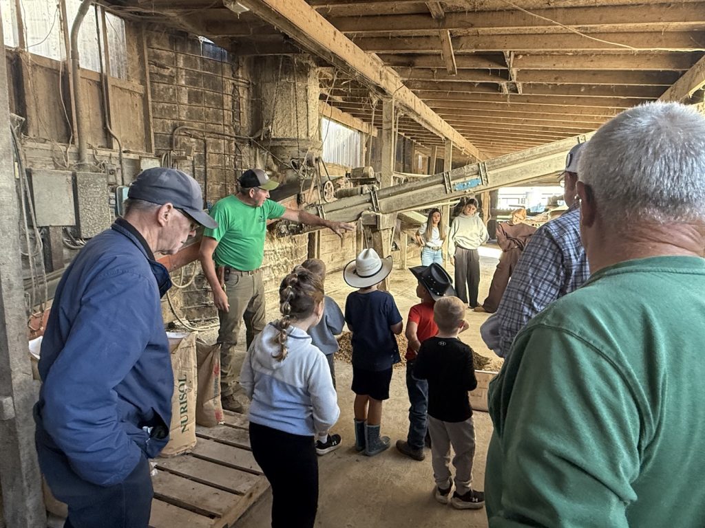 Farmer explains a grain mill to visitors