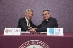 Walsh University President President Tim Collins and Archbishop Bashar Matti Warda, CSsR, the Chaldean Catholic Archbishop of Erbil in Iraq, shake hands after signing an agreement.