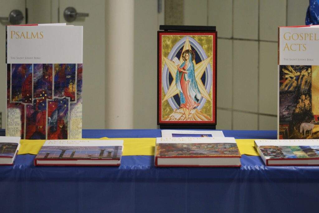 Several books displayed on a table with a blue table cloth