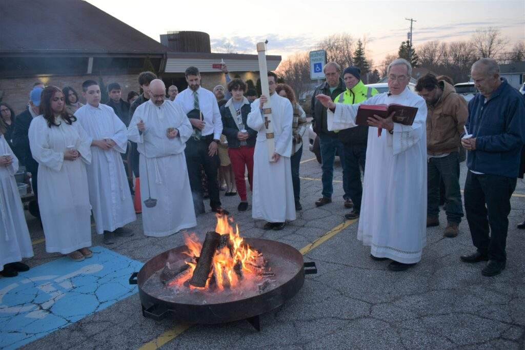 Fr. Thomas and parishioners gather around the fire at the Vigil.