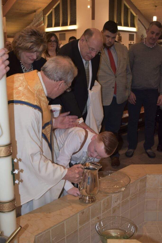 Fr. Thomas baptizes a young boy at the Easter Vigil