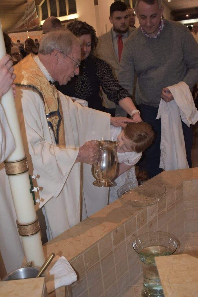 Fr. Thomas baptizes a young girl at the Easter Vigil