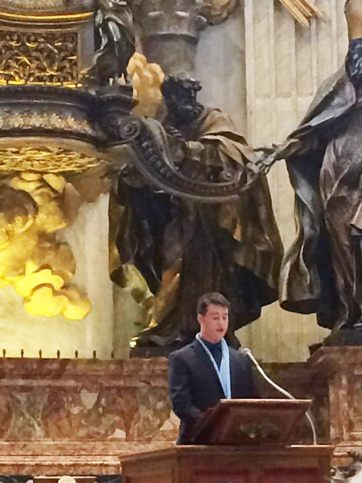 Jacob stands at an ornate ambo, doing a reading at the vatican.