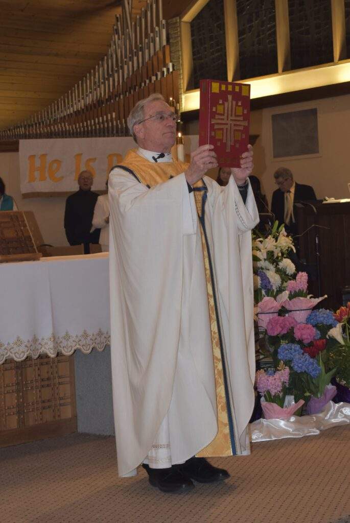 Fr. Thomas raises the bible at the Easter Vigil