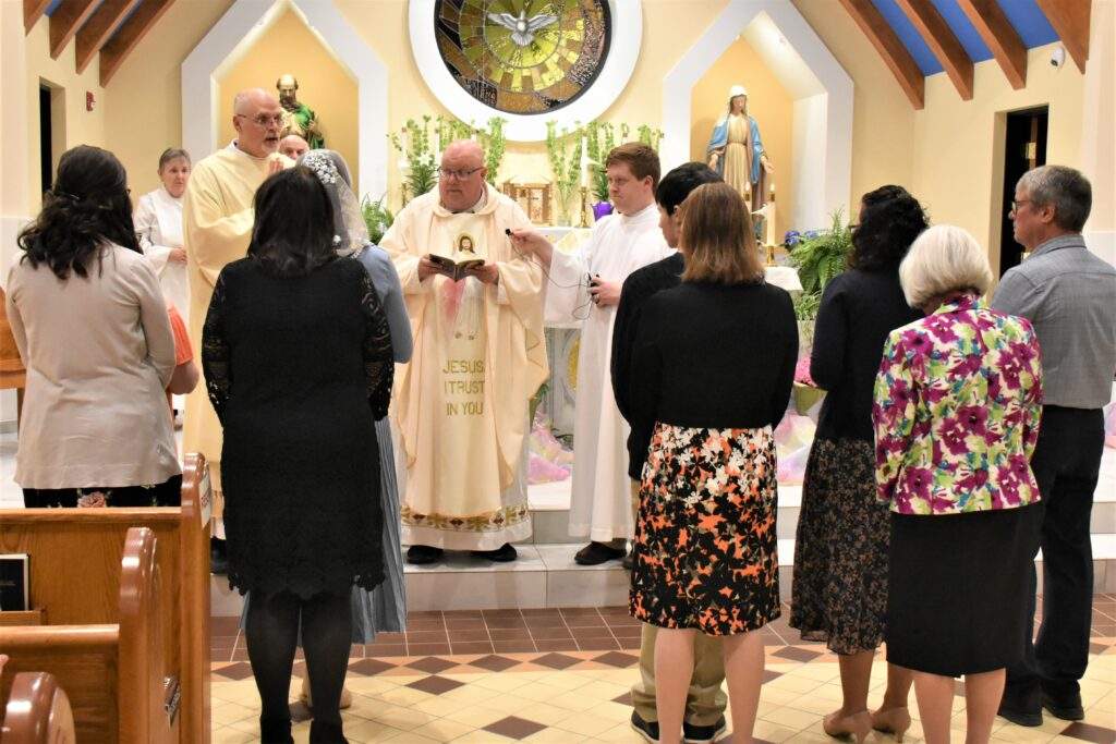 Candidates stand at the altar before being received into the faith.