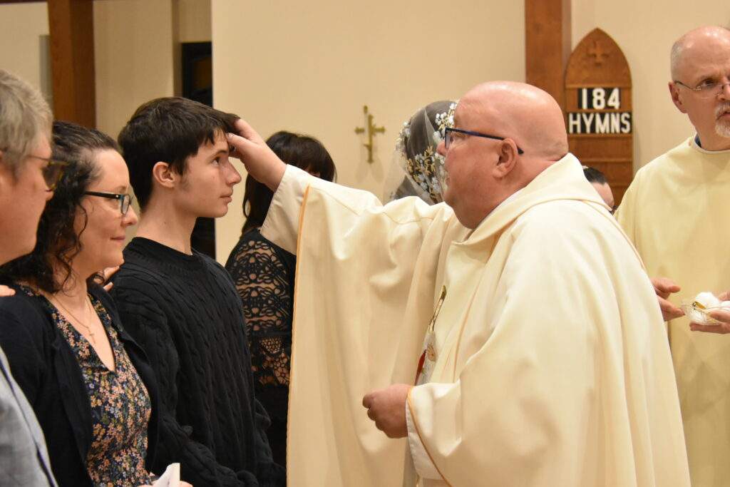 Fr. Misbrener blesses a confirmation candidate