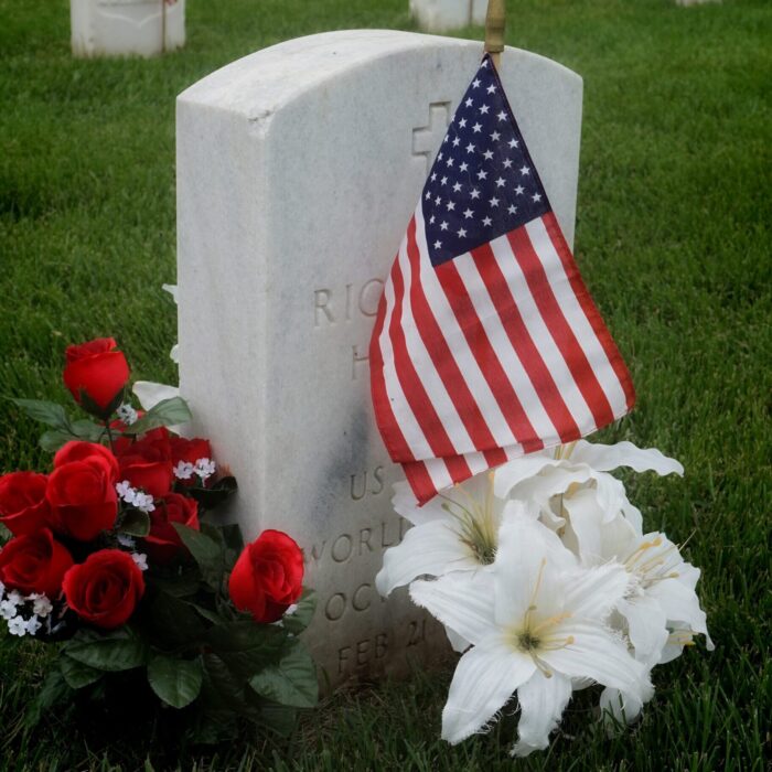Flowers and American flag at veterans gravestone