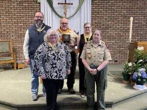 The five honorees stand with their awards near the altar.