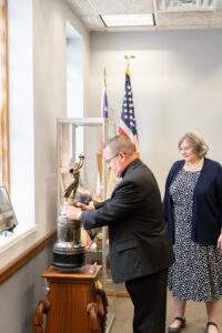 bishop examines trophy in 80th anniversary exhibit