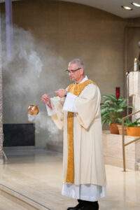 Priest incenses the people