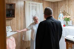 Karen Siegler shows Bishop Bonnar artifacts from Rhoda's life in Rhoda's home