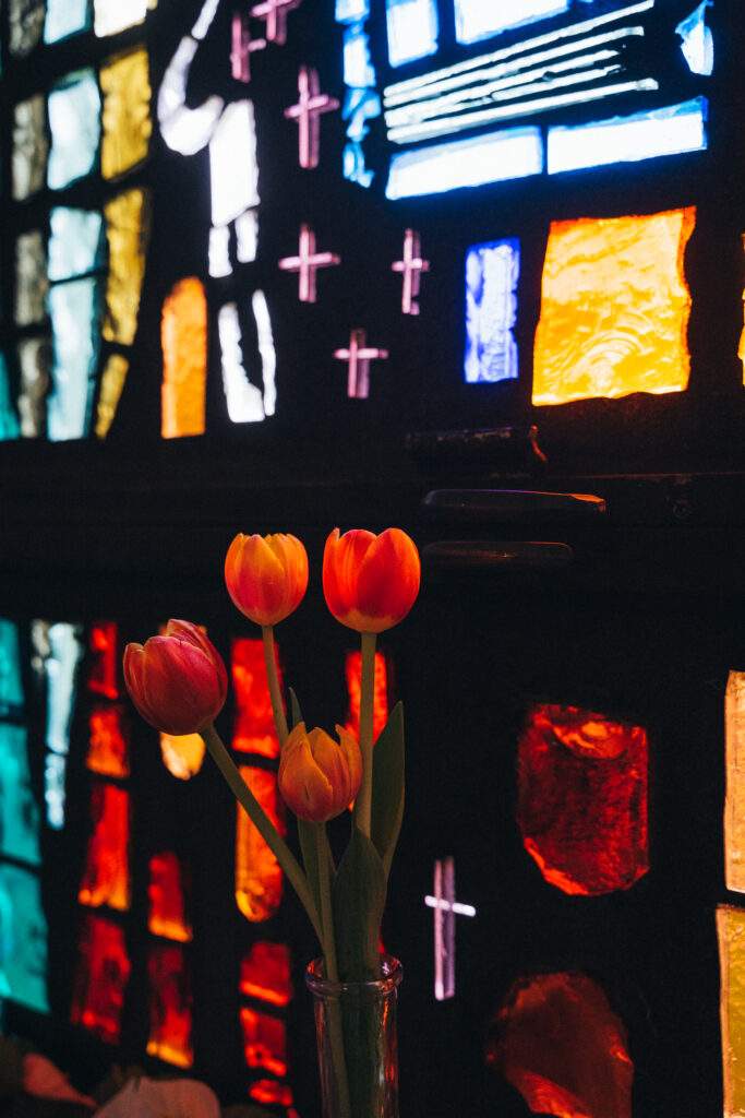 A vase of tulips in front of stained glass at Sacred Heart Parish in Rock Creek. Photo by Brian Keith