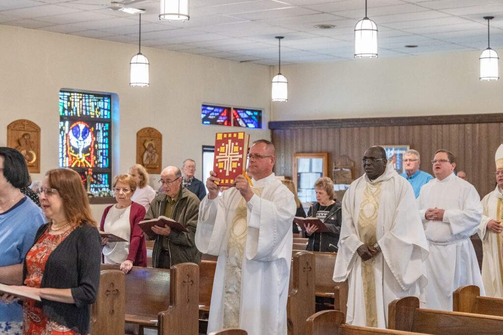 Priests, deacons and Bishop Bonnar walk in procession at Sacred Heart Parish in Rock Creek. Photo by Brian Keith