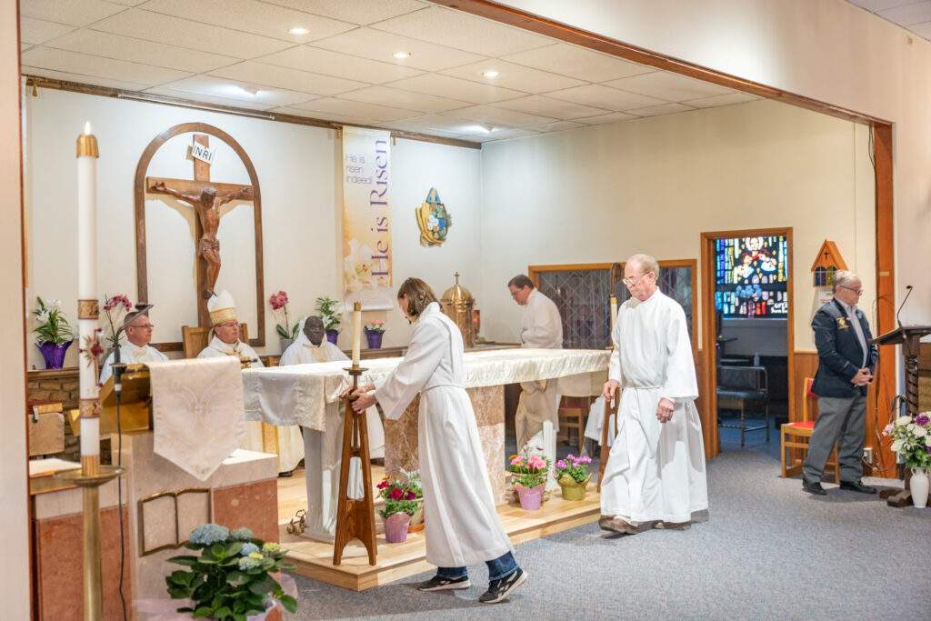 Servers place candles on either side of the altar at Sacred Heart Parish in Rock Creek. Photo by Brian Keith.