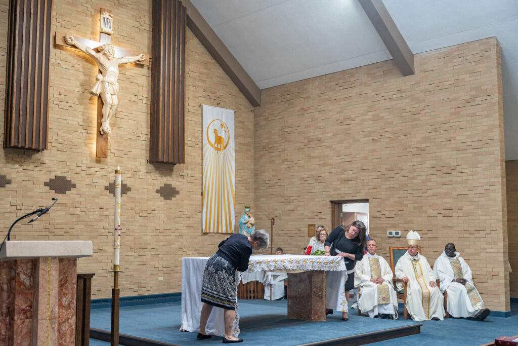 Women cover the altar in an altar cloth at St. Mary Parish in Orwell. Photo by Brian Keith