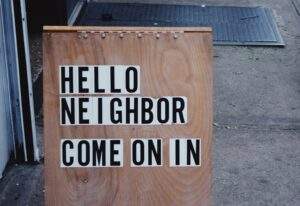 sign reading "hello neighbor come on in"